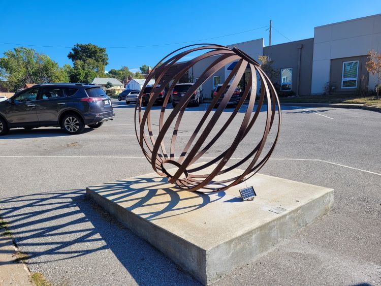 round sphere sculpture on stone base