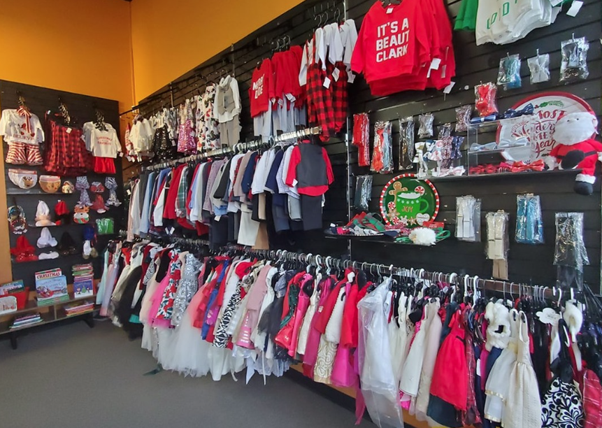 red and white and blue childrens clothing hanging on racks in a store