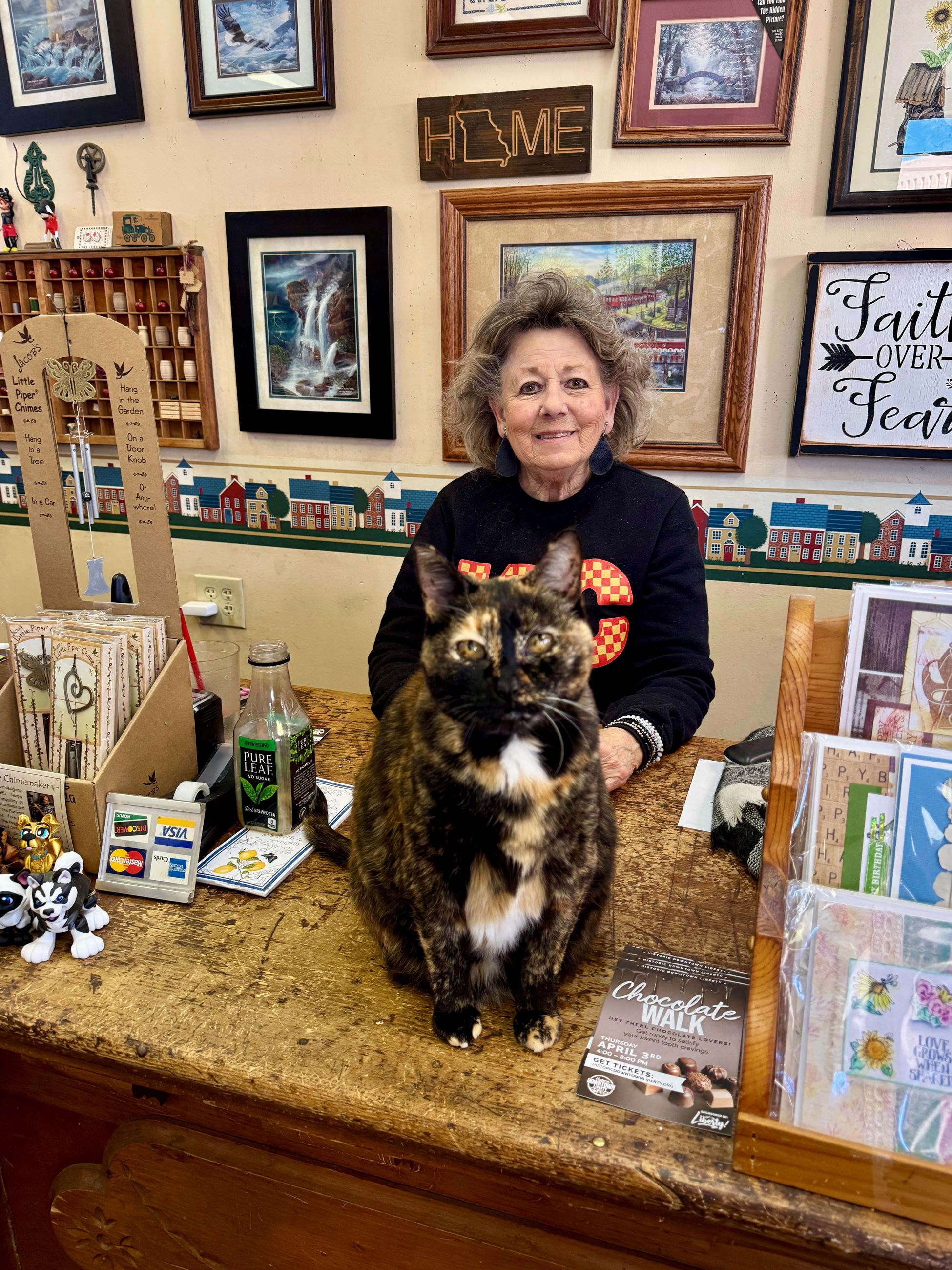 Woman in black sweatshirt with calico cat