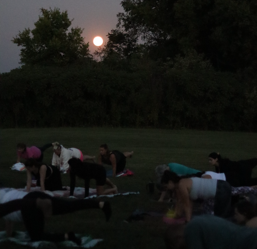 women doing yoga in the dark by moonlight