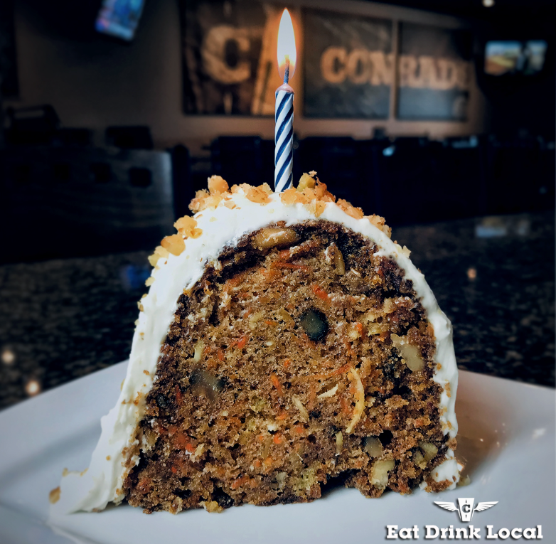 Giant slice of carrot cake with a candle on top