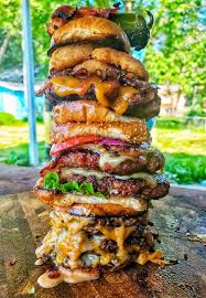 meat mountain challenge of 10 burgers stacked with buns and condiments