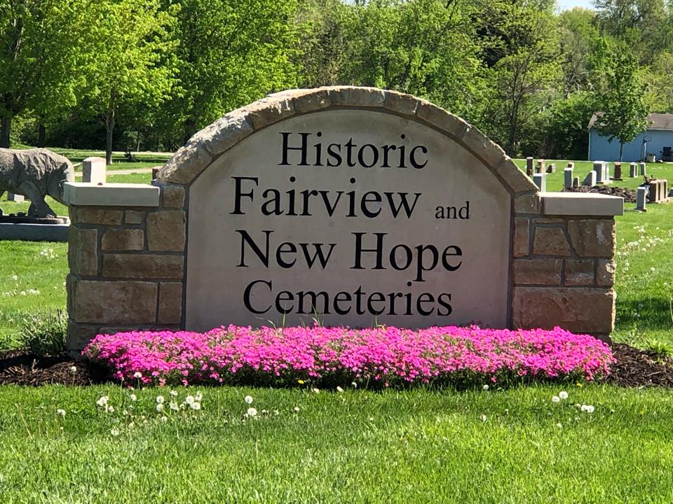 pink flowers in front of cemetery entrance