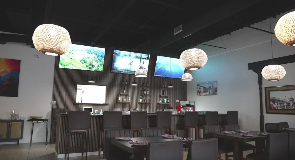sleek, dark bar and restaurant interior with tv screen